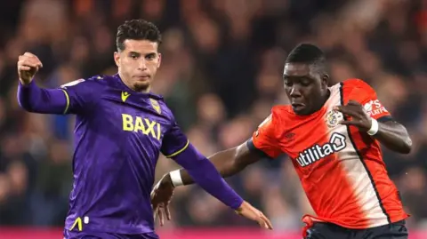 Oxford's Ruben Rodrigues battles with Luton's Marvelous Nakamba