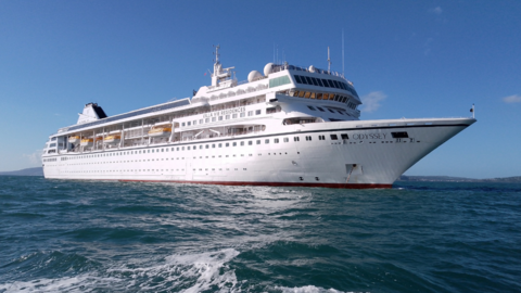 White cruise ship, has many floors of windows along the side of the ship. Lifeboats can be seen attached to the side with Villa Vie Residences written in the middle and Odyssey on the front.