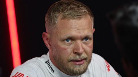 Kevin Magnussen looks on