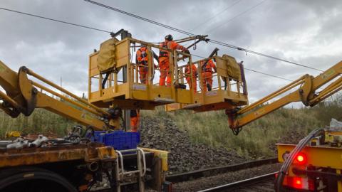 Engineers work on the damaged lines about the track at Beattock