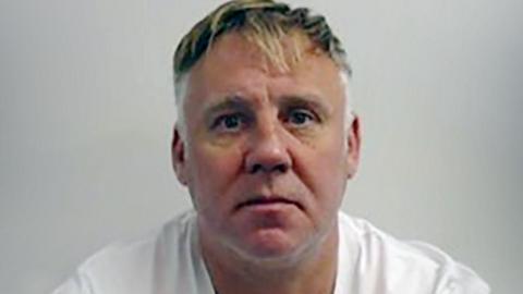 Police mugshot of Jamie Stevenson, who is looking directly at the camera, wearing a white tshirt