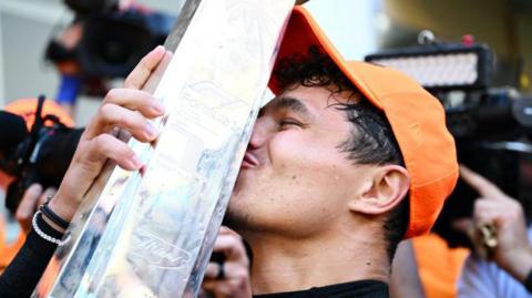 Lando Norris kissing his trophy at the Miami GP.