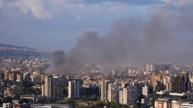 Black smoke is seen billowing over apartment blocks in Beirut following Israeli air strikes