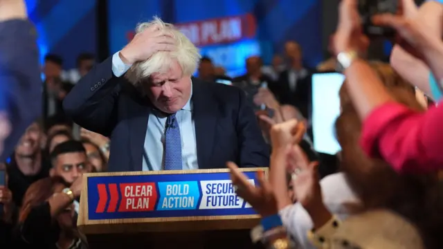 Boris Johnson with his head in his hands