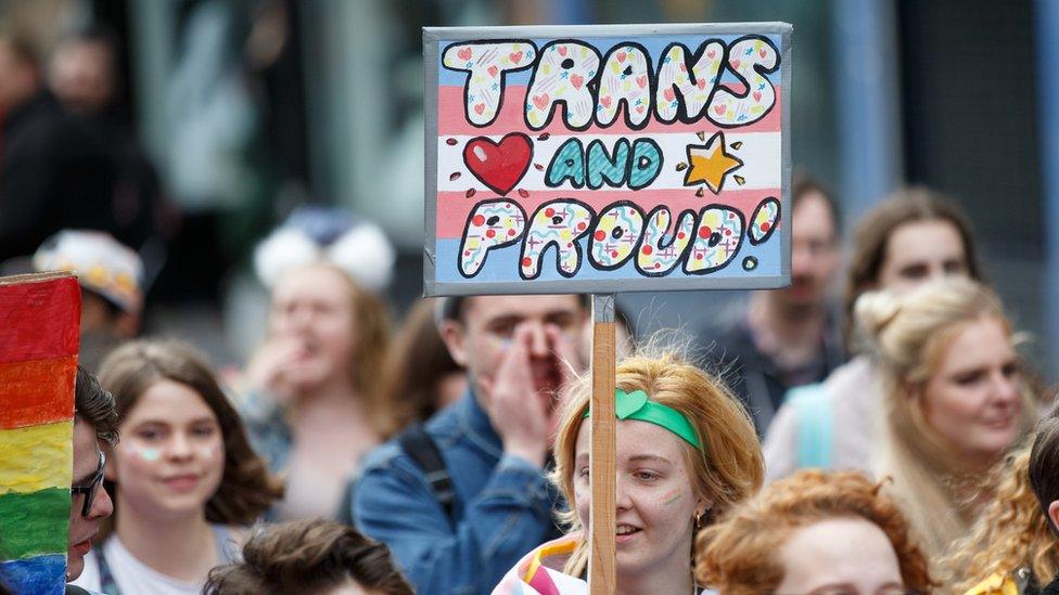 A participant holds a sign saying "Trans and Proud" during the Glasgow Pride march