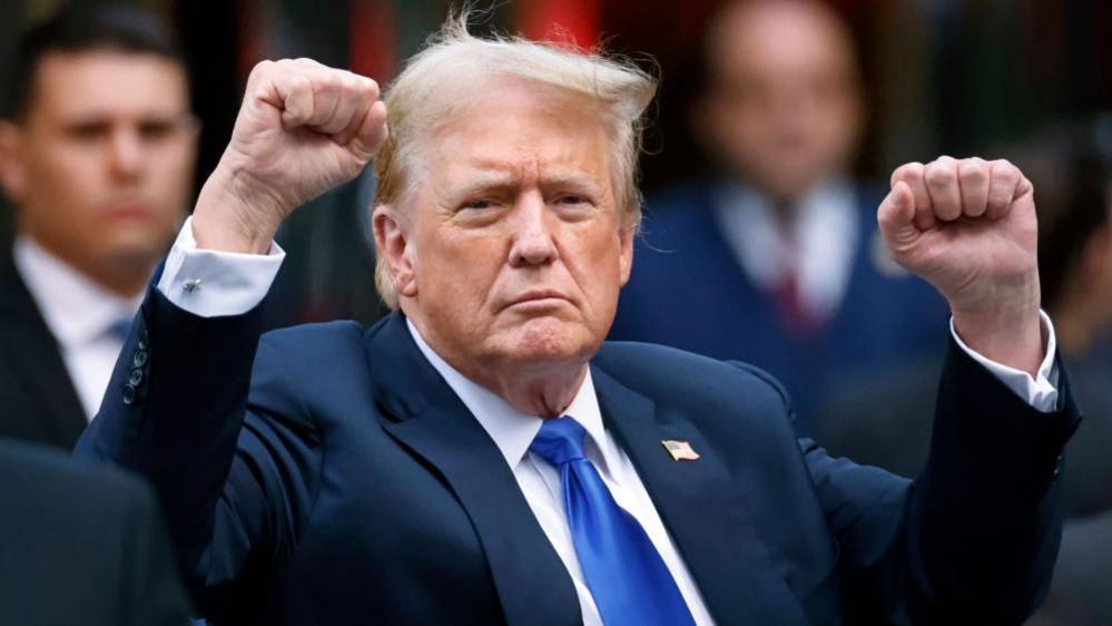 Donald Trump raises two fists outside Trump Tower