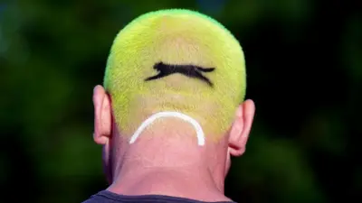 A person at Southfields stations with hair in the style of a tennis ball, on day one of the 2024 Wimbledon Championships at the All England Lawn Tennis and Croquet Club, Londo