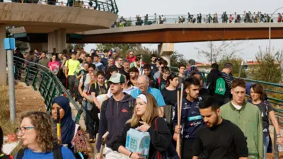 voluntarios cruzan un puente para ayudar a los municipios valencianos afectados por la dana 