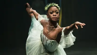 Michaela DePrince con una traje blanco bailando.