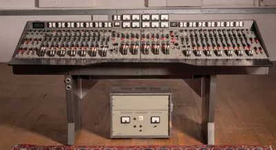 The EMI TGI12345 console sits in a room. It has countless switches and dials to help record music.