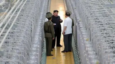 Kim junto a militares y otros funcionarios en una instalación nuclear.