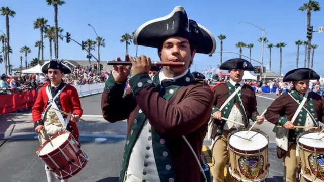 Hombres vestidos como collonos revolucionarios en un desfile del 4 de julio en Estados Unidos