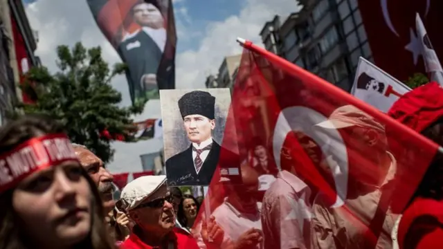 Gente celebrando en aniversario de Turquía con fotos de Atatürk.