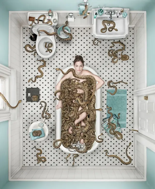Mujer dentro de una bañera llena de serpientes.