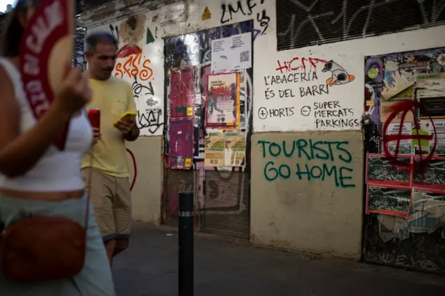 Un grafiti en Barcelona lee en inglés: "Turistas váyanse a casa"