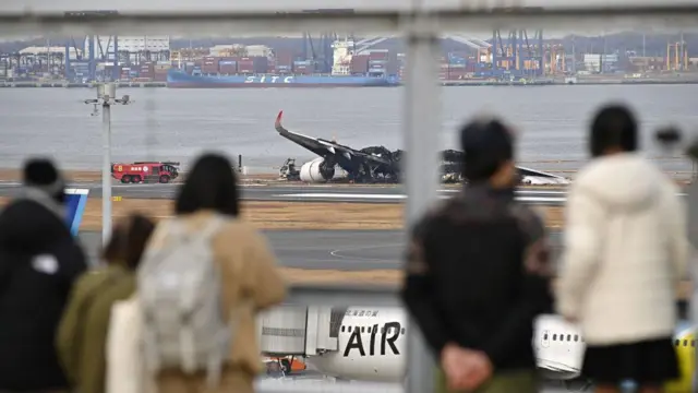 Pasajeros miran el avión calcinado