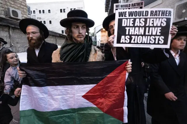 Judíos ortodoxos antisionistas manifestándose con bandera palestina