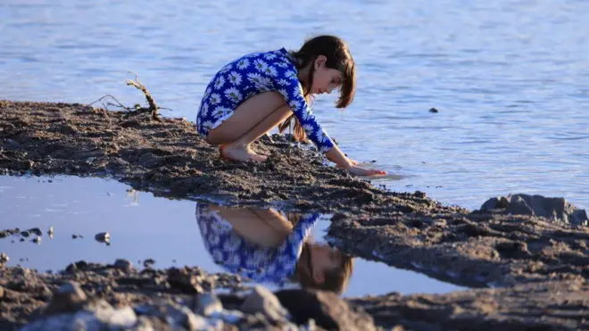 Una niña juega con el agua. 