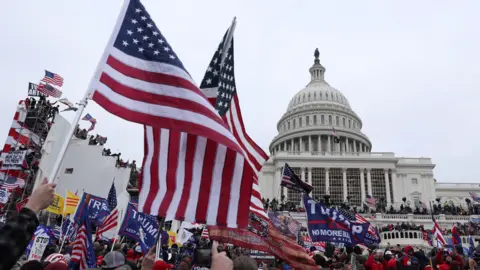 Protesters with American flags and Trump 2020 flags gather outside the US Capitol after breaching police security lines 