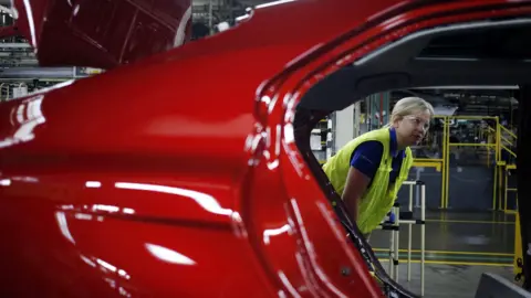 Plant manager looks at vehicle on an assembly line at the Toyota factory in Georgetown, Kentucky.