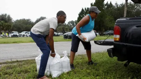 Shon Rodriguez and his mother Millie load the car with sandbags, as they are distributed to Pinellas County residents before the expected arrival of Tropical Storm Milton, in Seminole, Florida, U.S. October 6, 2024