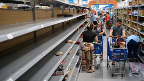 Reuters People pictured near partially empty shelves for non-perishable food at a supermarket ahead of the arrival of Hurricane Beryl, in Cancun, Mexico July 2, 2024