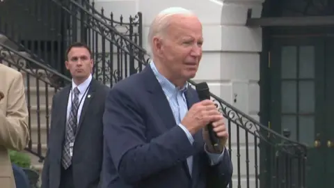 President Biden has a microphone and is addressing a comment from the crowd at the July 4 White House celebrations.