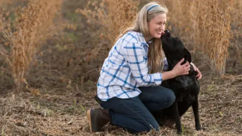 Sean Rayford photography  Rachael Sharp, a third-generation farmer in the US state of South Carolina. With Laney the dog.