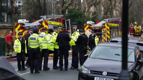 Fire engines and police officers on Seagrave Road in Fulham.