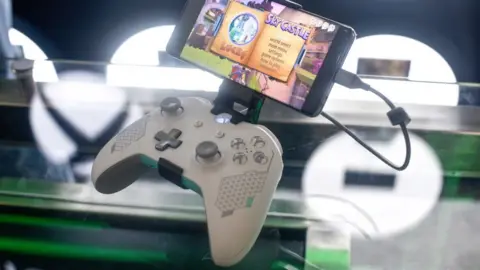 Getty Images An Xbox controller is seen with a phone clipped to its top