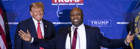 Getty Images Senator Tim Scott, a Republican from South Carolina, right, speaks as he stands next to former US President Donald Trump during a campaign event in Concord, New Hampshire, US, on Friday, Jan. 19, 2024.