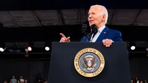 Joe Biden gestures while speaking at a podium at North Carolina State Fairgrounds in Raleigh, North Carolina, on 28 June