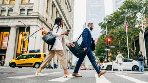 People in suits crossing a New York street