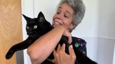 Anthea Slade holding her black cat