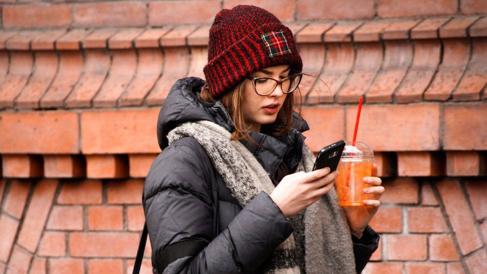 Woman scrolls through phone