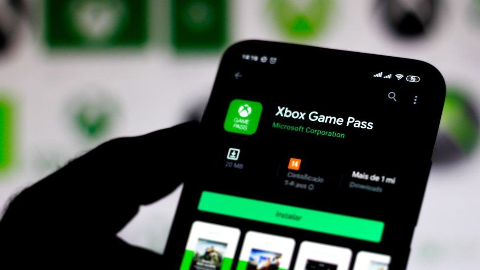 The Xbox Game Pass app is seen on a phone screen against a blurred background