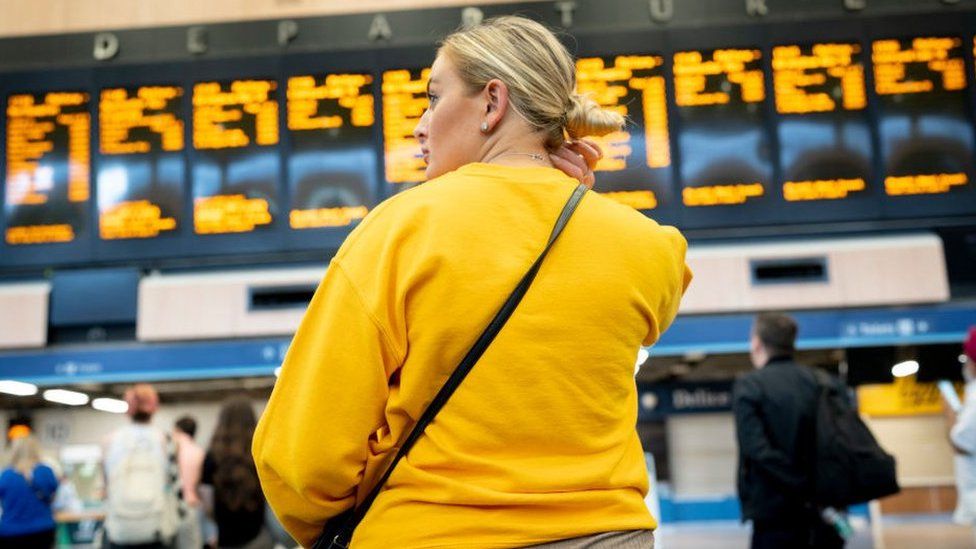 Woman looks at rail timetable