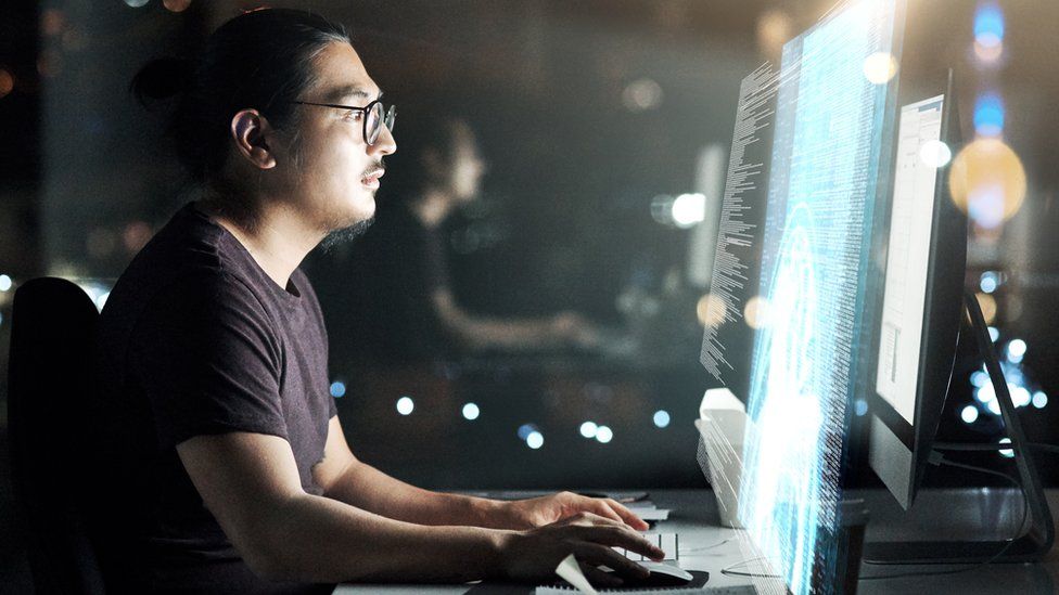 Stock shot of man at terminal working on computer code