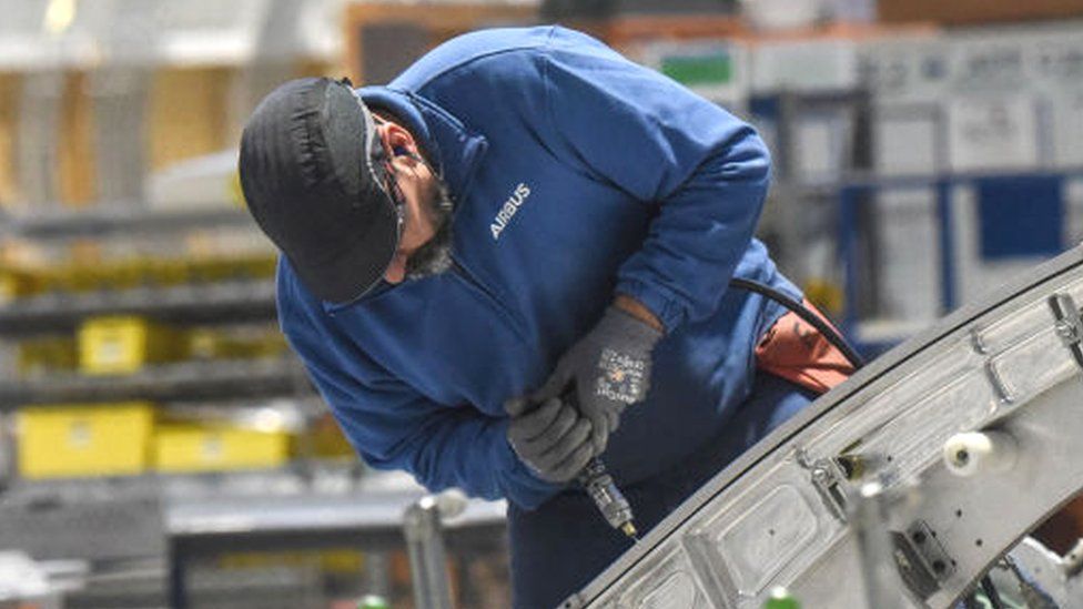 An Airbus' employee works on an aircraft part of the Airbus A350 at the Airbus Atlantic plant in Bouguenais, near Nantes, western France