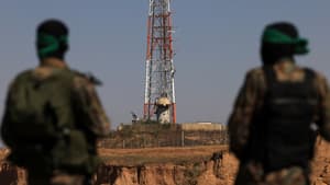 Des combattants palestiniens des Brigades al-Qassam regardent une antenne de surveillance israélienne, lors d'un défilé militaire marquant l'anniversaire de la guerre de 2014 avec Israël, près de la frontière dans le centre de la bande de Gaza, le 19 juillet 2023.