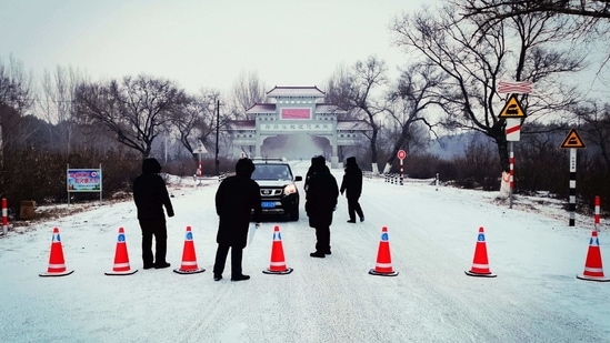 Security personnel direct a commuter in Ang'angxi district as the province prepares to declare an 