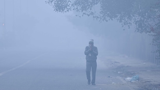 A man in winter wear jogs on a foggy morning at Pusa Road in New Delhi on January 19. According to the India Meteorological Department (IMD), Delhi's minimum temperature settled at 7.8 degrees Celsius, a notch above normal, on January 20.(Sanchit Khanna / HT Photo)