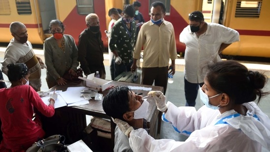 A Brihanmumbai Municipal Corporation (BMC) health worker collects a swab sample from a passenger at Dadar Station in Mumbai on January 19. Maharashtra on January 21 crossed the 2 million mark for Covid-19 cases, 319 days since the first infection was detected on March 9, 2020.(Satish Bate / HT Photo)