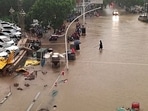 People wade through floodwaters on a road amid heavy rainfall in Zhengzhou, Henan province in China REUTERS(VIA REUTERS)