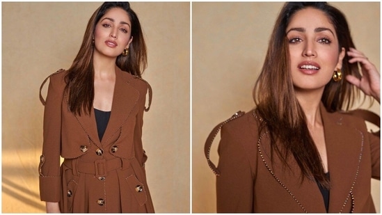 Yami Gautam once again reached the sets of The Kapil Sharma Show to promote her upcoming film Dasvi. For the episode, the actor donned a stylish long trench-coat inspired brown jacket with multiple buttons.(Instagram/@yamigautam)