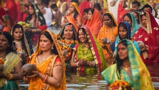 Devotees are seen performing rituals inside an artificial pond created by the Delhi government for Chhath Puja in New Delhi.(Sanchit Khanna/ Hindustan Times)