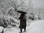 A person walks on snow-clad road in Srinagar. (Waseem Andrabi/HT photo)