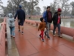 Amid light rain spell, people seen walking around the newly revamped India Gate complex.(Vipin Kumar/HT Photo)