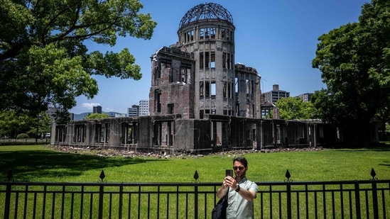 A man takes pictures in front of Hiroshima Prefectural Industrial Promotion Hall, commonly known as the atomic bomb dome in Hiroshima. August 6, 2024, observed solemnly as Hiroshima Day around the world, will be the 79th anniversary of the atomic bombing of the Japanese city in the final year of World War II as on this day in 1945, the United States dropped the very first deployed nuclear bomb in the city of Hiroshima, wiping out an estimated 39 percent of the population, most of who were civilians. Today, Hiroshima Prefectural stands as a poignant symbol of peace and resilience and visiting Hiroshima Prefectural on Hiroshima Day is not just a journey through history; it is an immersive experience that blends solemn remembrance with a powerful message of hope for future generations. Trips and tours to Hiroshima Prefectural provide a deeper understanding of Hiroshima's transformation from a site of tragedy to a beacon of peace -&nbsp;(Photo by Philip FONG / AFP)