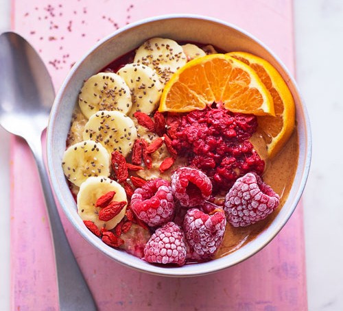 Bowl of porridge topped with colourful fruit